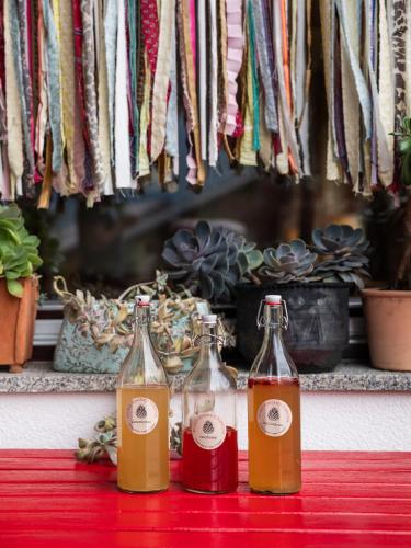 three bottles sitting on a red table at Frida am Wald in Rasùn di Sotto