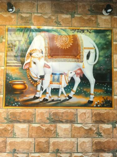 a painting of a cow and a calf on a wall at farmer homestay yercaud in Yercaud