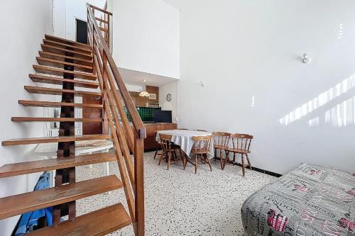 - un escalier dans une pièce avec une table et des chaises dans l'établissement Spacious house near the beach, à Port-la-Nouvelle