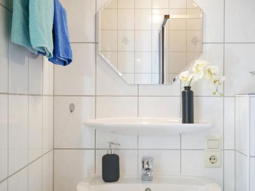 a white bathroom with a sink and a mirror at Ferienwohnung Ketterer in Breitnau