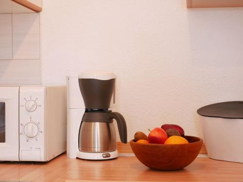 a coffee maker sitting next to a bowl of fruit at Ferienwohnung Ketterer in Breitnau
