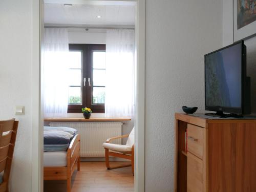 a room with a television and a bedroom with a window at Ferienwohnung Ketterer in Breitnau