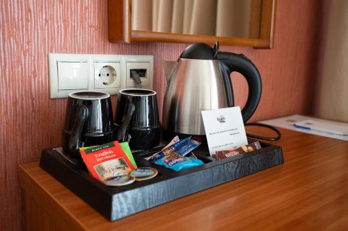 a tray with a tea pot and cups on a table at Queen Olga Hotel in Thessaloniki