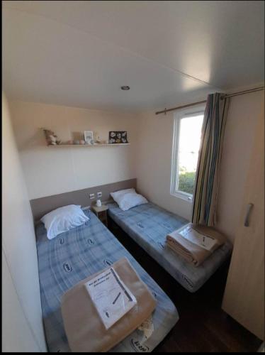 deux lits dans une petite pièce avec une fenêtre dans l'établissement Bungalow Boofzheim Europa Park, à Boofzheim