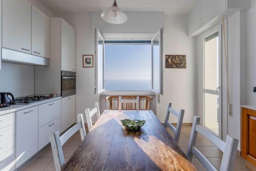 a kitchen with a wooden table and chairs and a window at Breath-taking Portofino Promontory Seaview in Pieve Ligure