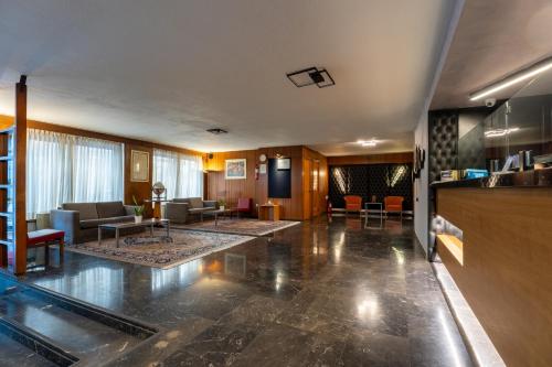 a lobby with a living room with couches and tables at Queen Olga Hotel in Thessaloniki