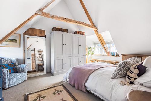 a bedroom with a bed and a chair in a room at Barton Cottage Bed and Breakfast in Broadmayne