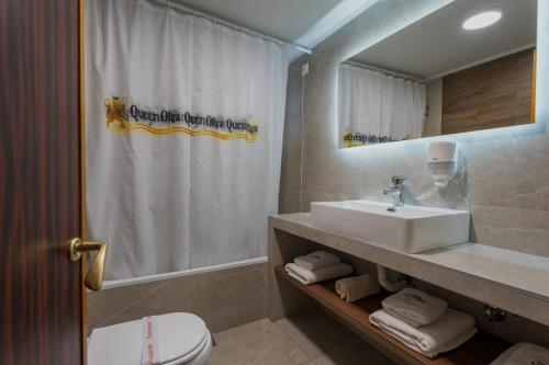 a bathroom with a sink and a toilet and a shower at Queen Olga Hotel in Thessaloniki