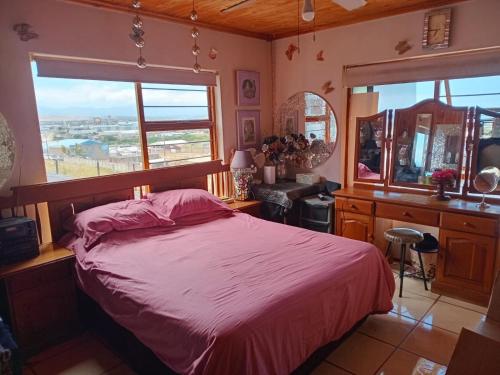 a bedroom with a bed and a large window at Lion's Cave 3 in Mossel Bay