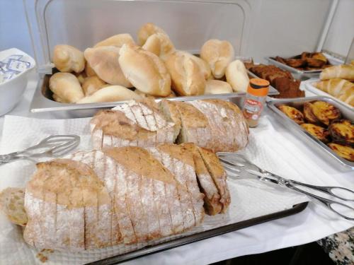 una mesa cubierta con bandejas de pan y otros alimentos en O Vicente, en Loriga