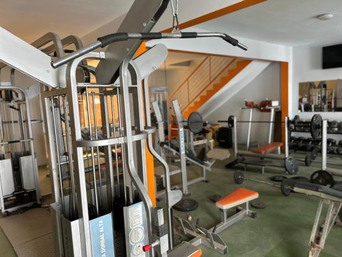 姆布尔Touraco Suite Hôtel Business的一间健身房,配有数台跑步机和举重器材