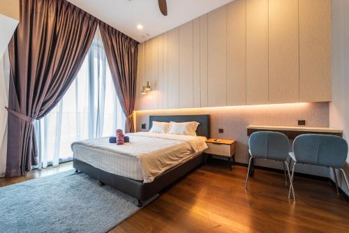 a bedroom with a bed and two blue chairs at Opus Residences by Centurypro in Kuala Lumpur