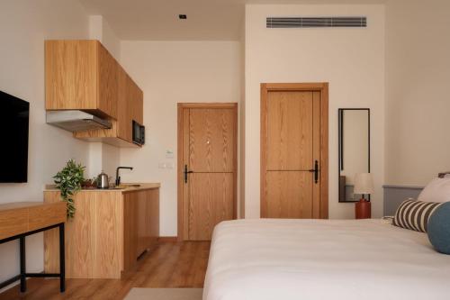 a bedroom with a bed and a tv and wooden cabinets at Brassbell l Downtown l Kasr Living l Tahrir sq in Cairo