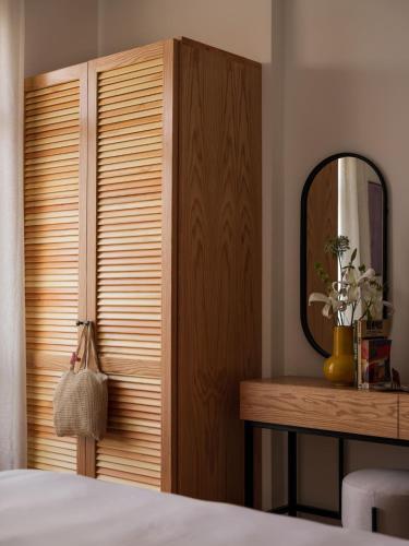 a bedroom with a wooden closet and a mirror at Brassbell l Downtown l Kasr Living l Tahrir sq in Cairo