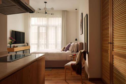 a bedroom with a bed and a kitchen with a window at Brassbell l Downtown l Kasr Living l Tahrir sq in Cairo