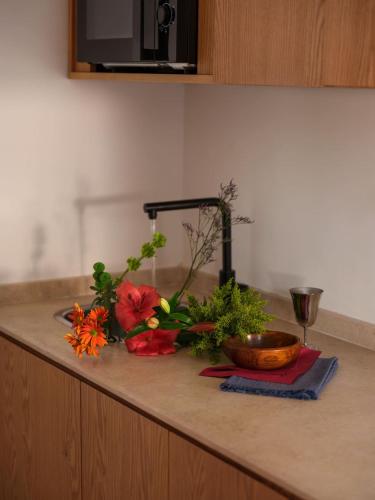 a counter top with flowers and a bowl on it at Brassbell l Downtown l Kasr Living l Tahrir sq in Cairo