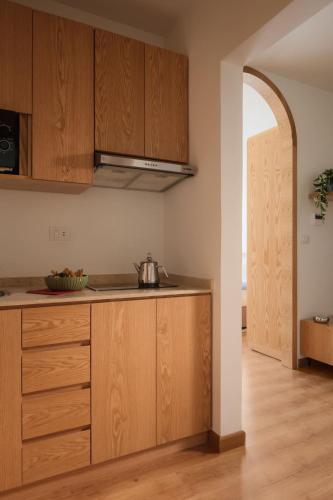 a kitchen with wooden cabinets and an open doorway at Brassbell l Downtown l Kasr Living l Tahrir sq in Cairo