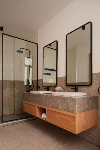 a bathroom with a large sink and two mirrors at Brassbell l Downtown l Kasr Living l Tahrir sq in Cairo