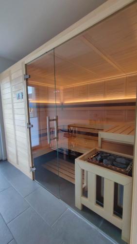 a glass shower in a room with a table at Villa Wildrose mit Sauna und Beachfußballplatz in Rheinsberg