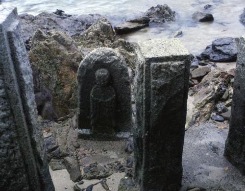 a stone statue sitting on the rocks near the water at Tabinoyado Ushionoakari Geiboso in Shima