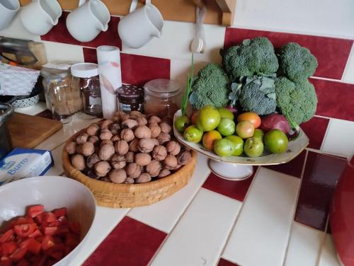 a counter top with two bowls of fruit and vegetables at Al Passo di Thalia in Ricadi