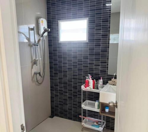 a bathroom with a shower with black tiled walls at Beautiful 2 Floor Home in Phuket Town in Phuket Town