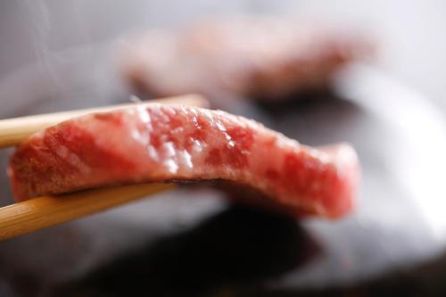 a piece of meat on a wooden chop stick at Tabinoyado Ushionoakari Geiboso in Shima