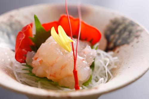 a white bowl of food with rice and vegetables at Tabinoyado Ushionoakari Geiboso in Shima