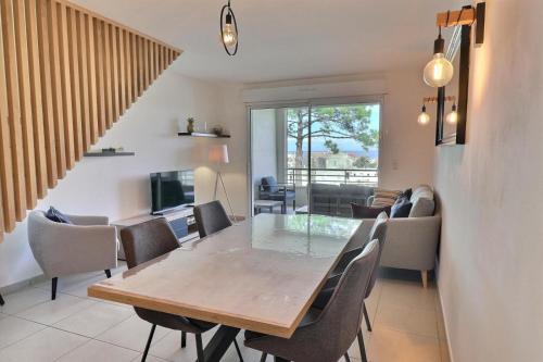 une salle à manger et un salon avec une table et des chaises dans l'établissement L'horizon bleu - Terrasse vue mer, à Algajola