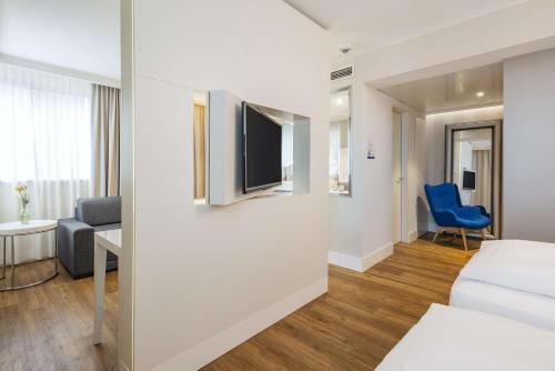 a hotel room with a bed and a tv at NH Hamburg Altona in Hamburg