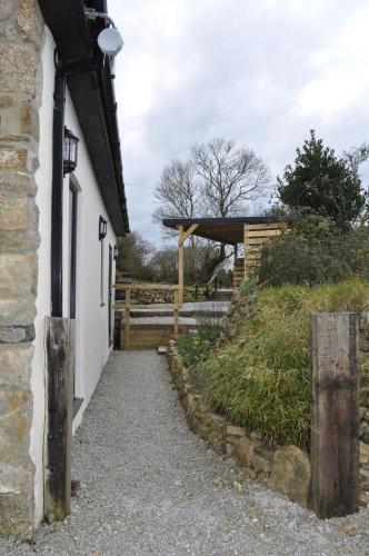 a building with a pathway next to a fence at Morley's in Stithians