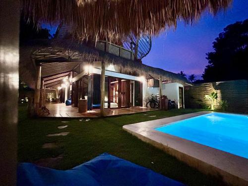a villa with a swimming pool at night at Villa Kesambi in Gili Air