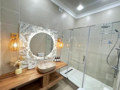 a bathroom with a sink and a shower and a mirror at Гостевой дом Burabay Grand Village in Borovoye