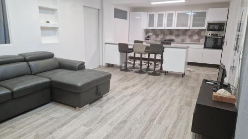 a living room with a couch and a kitchen at Appartement cozy et confort avec JACUZZI proche CDG Parc Astérix Chantilly Paris in Fosses
