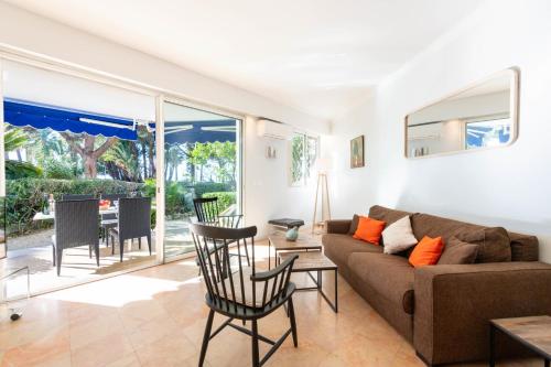 un salon avec un canapé, une table et des chaises dans l'établissement Garden-Level Apartment in Palm Beach with Garage, à Cannes
