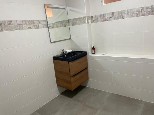 a bathroom with a black sink and a mirror at Appartement cozy et confort avec JACUZZI proche CDG Parc Astérix Chantilly Paris in Fosses