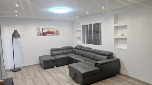 a living room with a couch and a lamp at Appartement cozy et confort avec JACUZZI proche CDG Parc Astérix Chantilly Paris in Fosses