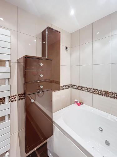 une salle de bain blanche avec une baignoire et une douche dans l'établissement La Marceline - 15 minutes from Compiègne, à Grandfresnoy