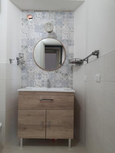 ein Badezimmer mit einem Waschbecken und einem Spiegel an der Wand in der Unterkunft Villa Giuseppina Miramare in San Menaio