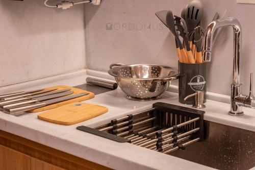 a kitchen counter with a sink with a bowl and utensils at O Melhor Lugar p/ Se Hospedar na Chapada Diamantina - Diamantino Residence - Lar Aconchego in Mucugê
