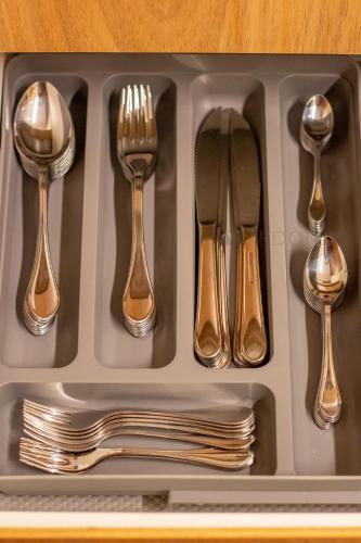 a tray of silver utensils with forks and spoons at O Melhor Lugar p/ Se Hospedar na Chapada Diamantina - Diamantino Residence - Lar Aconchego in Mucugê