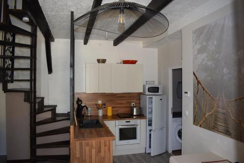 Il comprend une cuisine avec un escalier et une cuisine avec un coin cuisine. dans l'établissement MAISON CLIMATISÉE - Vallée Du Tarn - BORD D'EAU, à Trébas