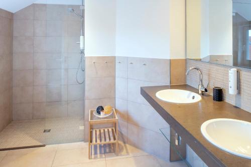 a bathroom with two sinks and a shower at Suitenhotel Idyll Heckenrose in Langeoog