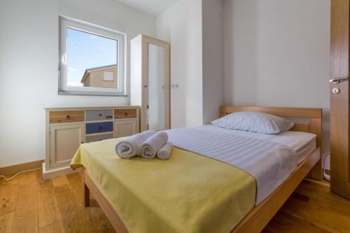 a bedroom with a bed with two towels on it at WHITE HOUSE PENTHOUSE in Dramalj