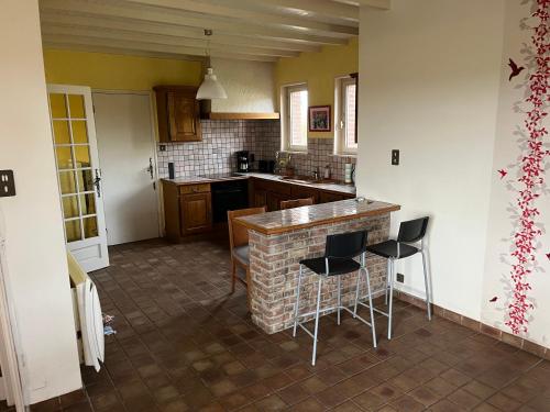 une cuisine avec un comptoir et deux tabourets dans l'établissement Les Quatre-Vingt, à Steenbecque