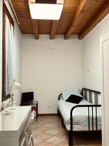 a small bedroom with a bed and a desk at Accogliente appartamento in centro Brescia in Brescia
