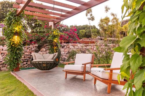a patio with two chairs and a swing at O Melhor Lugar p/ Se Hospedar na Chapada Diamantina - Diamantino Residence - Lar Aconchego in Mucugê