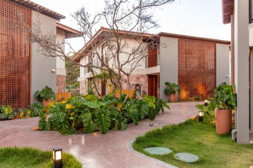 a courtyard with plants in front of a building at O Melhor Lugar p/ Se Hospedar na Chapada Diamantina - Diamantino Residence - Lar Aconchego in Mucugê