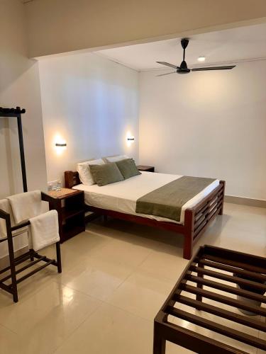 a bedroom with a bed and a chair at Sea Change in Talpe