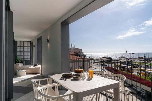a white table and chairs on a balcony with the ocean at Savoy Insular V by An Island Apart in Funchal